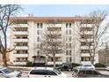 Stately building with multiple balconies, mature trees, and street-level parking at 1365 Columbine St # 301, Denver, CO 80206