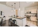 Well-lit kitchen featuring an island with bar stools, white cabinetry, and stainless steel appliances at 1200 Cherokee St # 206, Denver, CO 80204