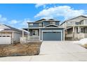 Beautiful blue two-story home with a covered front porch, two-car garage and landscaped yard at 2165 Peralta Loop, Castle Rock, CO 80104