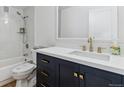 Updated bathroom with dark vanity, white quartz countertop, and gold fixtures at 775 S Alton Way # 2C, Denver, CO 80247