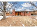 Inviting front of a brick home with a wood garage door, a wreath on the front, and landscaped yard at 2700 S High St, Denver, CO 80210