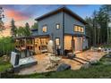 Backyard includes a hot tub, dining set, and stone patio, perfect for relaxation and outdoor dining at 6803 Snowshoe Trl, Evergreen, CO 80439