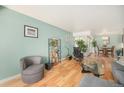 Living area with hardwood floors, a cozy chair, and seamless access to the dining area at 1223 Race St # 402, Denver, CO 80206