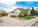 A spacious driveway leads to a two-car garage, complemented by mature landscaping, creating a welcoming entrance at 5191 S Hannibal Way, Centennial, CO 80015