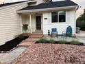 Charming home featuring a cozy front porch, decorative rocks, and a well-maintained landscaped yard at 7586 Chase St, Arvada, CO 80003