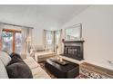 Inviting living room featuring a fireplace, neutral decor, hardwood floors, and large windows at 7586 Chase St, Arvada, CO 80003