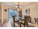 Cozy dining area featuring glass table, stylish chandelier, and access to outdoor space at 12835 Mayfair Way # C, Englewood, CO 80112