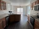 A kitchen area featuring granite countertops, stainless steel appliances, and dark laminate flooring at 20000 E Mitchell Pl # 35, Denver, CO 80249