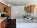 Kitchen with granite countertops, wooden cabinets, stainless steel appliances, and dark laminate flooring at 20000 E Mitchell Pl # 35, Denver, CO 80249