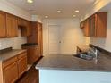 A spacious kitchen with wood cabinets, gray countertops, and stainless steel sink with natural lighting at 20000 E Mitchell Pl # 35, Denver, CO 80249