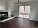 Cozy living room featuring dark hardwood floors, a fireplace, and sliding glass doors leading to patio at 20000 E Mitchell Pl # 35, Denver, CO 80249