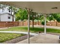 Relaxing covered patio overlooking a large, shaded backyard with a wood fence for privacy at 209 S 13Th Ave, Brighton, CO 80601