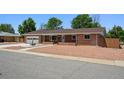Charming single-story brick house with a well-maintained front yard, driveway, and attached garage at 209 S 13Th Ave, Brighton, CO 80601
