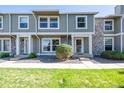 Exterior view of townhome featuring stone accents, a well-manicured lawn, and a sidewalk at 10311 E Evans Ave # 133, Aurora, CO 80247