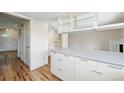 Modern kitchen with wood floors, white cabinets, and island featuring a light countertop at 10311 E Evans Ave # 133, Aurora, CO 80247