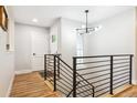 Modern entryway with wood floors, sleek railings and stylish light fixture at 5553 S Datura St, Littleton, CO 80120
