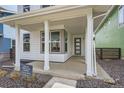 Inviting front porch with white columns and a modern front door at 918 Promenade Dr, Superior, CO 80027