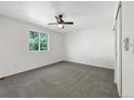 Cozy bedroom featuring plush carpet, neutral walls, a ceiling fan, and a large window at 542 Hawthorn Cir, Frederick, CO 80530