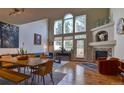 Bright living room with high ceilings, hardwood floors, fireplace, and large windows offering scenic views at 11257 W Radcliffe Dr, Littleton, CO 80127