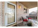 Cozy front porch featuring brick accents, seating, and a welcoming entryway at 18734 E Linvale Pl, Aurora, CO 80013