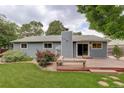 Backyard with a wooden deck, a bench, mature trees and a lush green lawn at 10883 Otis Cir, Westminster, CO 80020