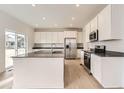 Modern kitchen with white cabinets, stainless steel appliances, and a center island at 5578 Inland Ave, Firestone, CO 80504