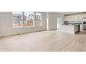 Bright and airy living room featuring hardwood floors and multiple windows for natural light at 5578 Inland Ave, Firestone, CO 80504