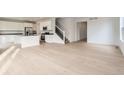 Spacious living room with hardwood floors leading into an open kitchen area at 5578 Inland Ave, Firestone, CO 80504