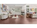 Bright living room features hardwood floors, large windows, and a cozy fireplace at 7664 S Ivanhoe Way, Centennial, CO 80112