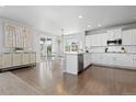 Bright, open kitchen with white cabinets, stainless appliances, and hardwood floors next to an eat-in dining area at 1315 Sidewinder Cir, Castle Rock, CO 80108
