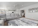 Spacious living room featuring a large gray sectional, open to the kitchen and staircase at 1315 Sidewinder Cir, Castle Rock, CO 80108