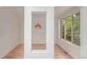 Bright entryway with hardwood floors, a unique pendant light, and large windows overlooking the lush greenery at 3322 W 26Th Ave, Denver, CO 80211