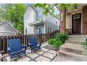 Inviting front yard with blue Adirondack chairs and a fenced patio area, perfect for relaxing outdoors at 3322 W 26Th Ave, Denver, CO 80211