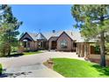 Beautiful home with a brick and stone facade, manicured lawn, and a circular driveway at 770 International Isle Dr, Castle Rock, CO 80108