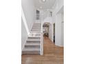 Bright entryway with hardwood floors, a staircase with white railings, and soaring ceilings at 4094 Bimini Ct, Boulder, CO 80301
