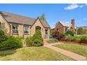 Charming brick home with a well-manicured lawn and inviting front porch seating at 2435 N Irving St, Denver, CO 80211