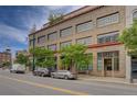 Brick building featuring large windows and mature trees lining the street at 1435 Wazee St # 408, Denver, CO 80202