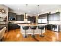 Gourmet kitchen boasts stainless steel appliances, an island with seating, and dark wood cabinetry at 18722 W 87Th Ave, Arvada, CO 80007