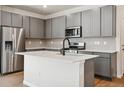 Contemporary kitchen features stainless steel appliances, gray cabinetry, modern countertops and island with sink at 14135 Deertrack Ln, Parker, CO 80134