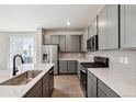 Modern kitchen showcasing stainless steel appliances, gray cabinets, island with sink, and stylish countertops at 14135 Deertrack Ln, Parker, CO 80134