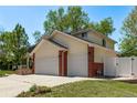 Spacious home exterior featuring a three-car garage, well-maintained lawn, and classic design elements at 105 Hawthorn St, Frederick, CO 80530