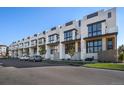 Row of modern townhomes featuring contemporary design, black framed windows, and manicured landscaping at 4214 E 8Th Pl, Denver, CO 80220