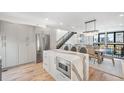 Bright modern kitchen with stainless steel appliances, waterfall island, and adjacent dining area at 4214 E 8Th Pl, Denver, CO 80220