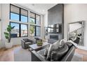 Modern living room with tall windows, fireplace, and comfortable seating arrangement at 4214 E 8Th Pl, Denver, CO 80220