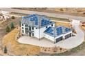 Aerial view showcasing the home's solar panels, three-car garage, and landscaped grounds at 8680 Summerlin Pl, Longmont, CO 80503