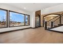 Bright living room with large windows, wood floors, and a decorative front door at 8680 Summerlin Pl, Longmont, CO 80503