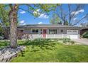 Charming ranch-style home with lush front lawn, red door, and inviting porch at 6150 S Southwood Dr, Centennial, CO 80121