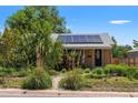 Charming home featuring solar panels, mature landscaping, and a welcoming front yard at 46 S Perry St, Denver, CO 80219