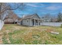 Charming single-story home featuring a well-manicured lawn and a white picket fence under a partly cloudy sky at 6660 Locust St, Commerce City, CO 80022