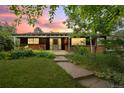 Inviting single-story home with brick accents, a covered porch, and a picturesque sunset backdrop at 7350 Field St, Arvada, CO 80005